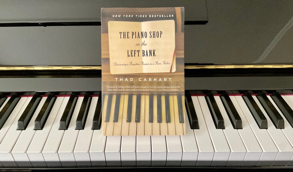 Książka "The Piano Shop on the Left Bank" na klawiaturze pianina